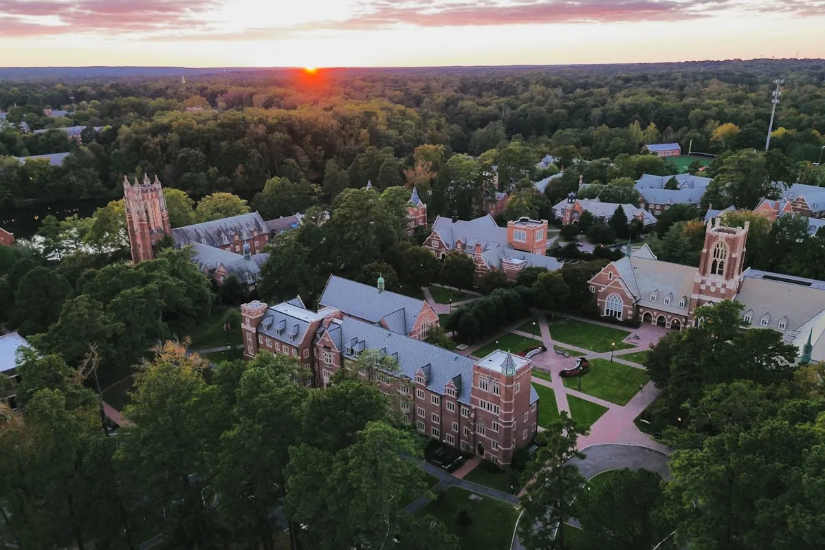 A college campus at sunset with warm light across the buildings and walkways