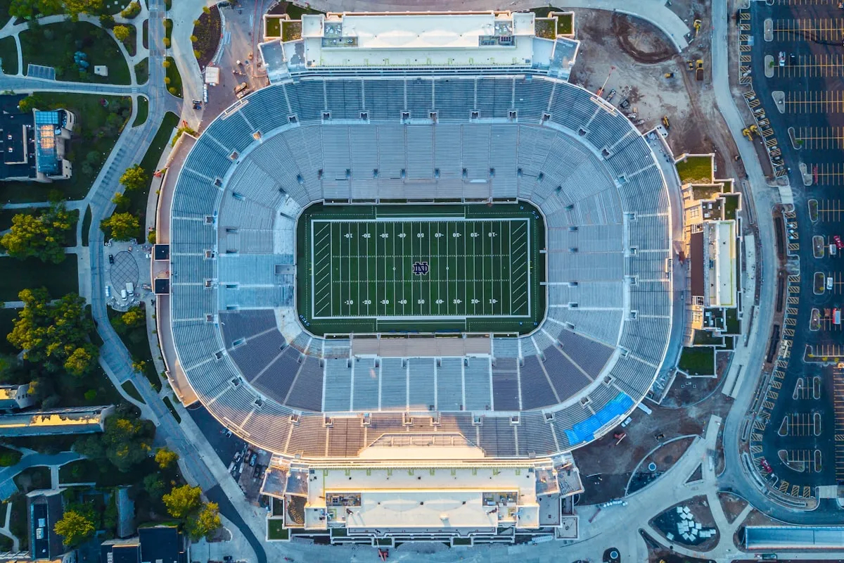 Aerial view of a large college football and track stadium surrounded by campus buildings and parking lots