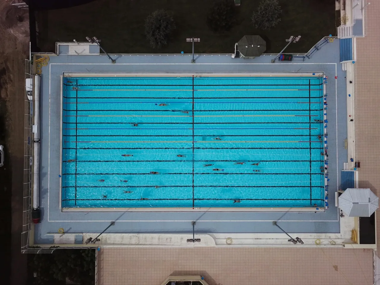 Aerial view of an Olympic-size swimming pool with lane dividers from directly overhead