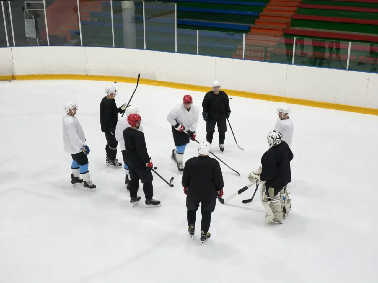 A hockey team huddled on the ice during practice