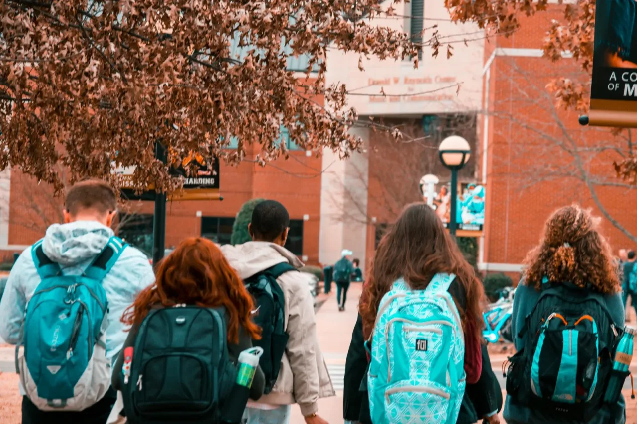 Students walking across a college campus in autumn